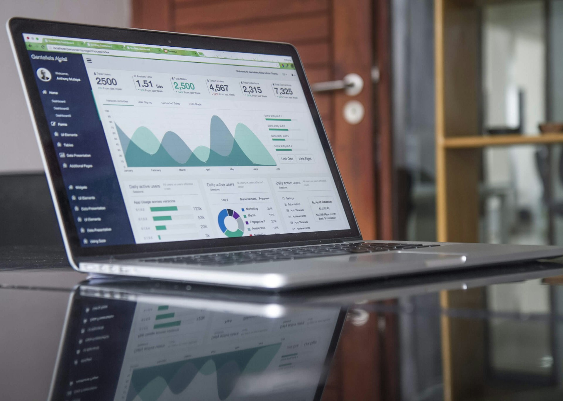 Persona che analizza grafici e appunti accanto a un laptop